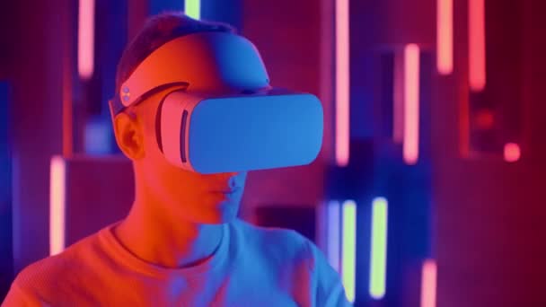 Junger Mann mit Vr-Brille im Neonlicht. — Stockvideo