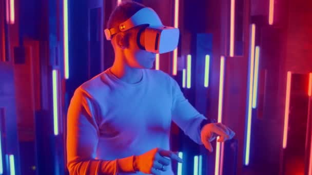 Giovane uomo mettendo VR auricolare sullo spettatore in luci al neon — Video Stock