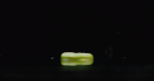 Des anneaux de citron vert tranchés tombent sur le verre avec des éclaboussures d'eau au ralenti .