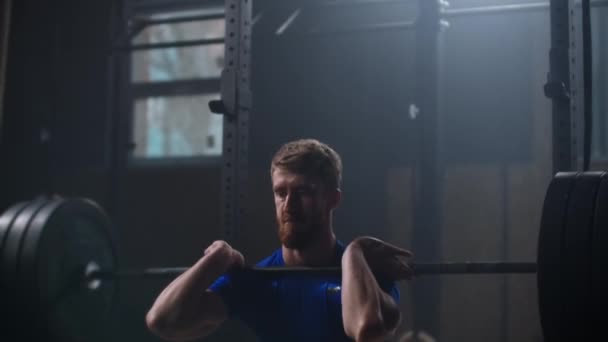 Jeune sportif soulevant lourd haltère. En bonne santé, musclé. Homme fort faisant haltère arracher exercice à la salle de gym au ralenti. Sportsman sur tapis d'exercice faisant des situations dans la salle de gym . — Video