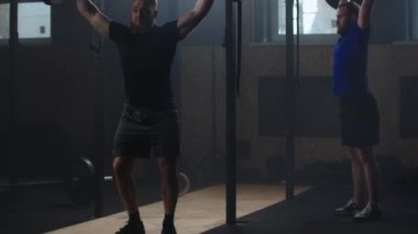 Two Strong man doing barbell snatch exercise at the gym in slow motion