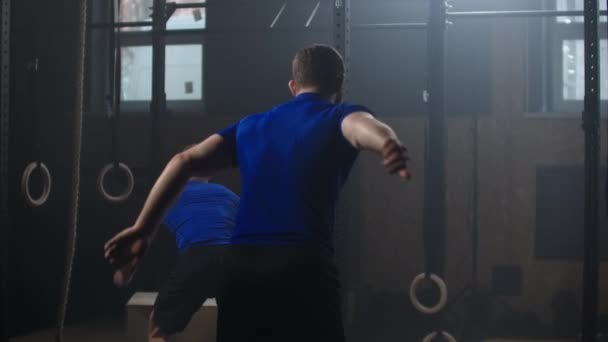 Due fitness uomo allenamento scatola salto esercizio sfida in palestra godendo sano stile di vita di bodybuilding pratica amici insieme rallentatore — Video Stock