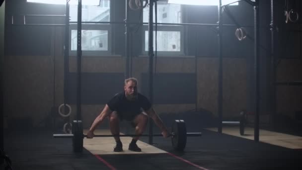 Strong man doing barbell snatch exercise at the gym in slow motion — ストック動画