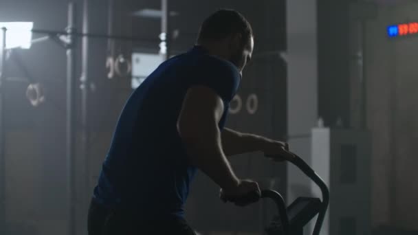 Zpomalený pohyb: Fitness muž na kole dělá spinning v posilovně. Přizpůsobit mladé ženy cvičení na tělocvičně kole — Stock video