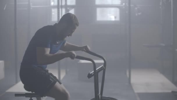 Trage beweging fitnessman doet Air Bike Workout In Gym. — Stockvideo