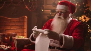 Santa Claus rolls up a scroll on Christmas eve and checks the list of children to whom gifts are prepared. Fantastic atmosphere