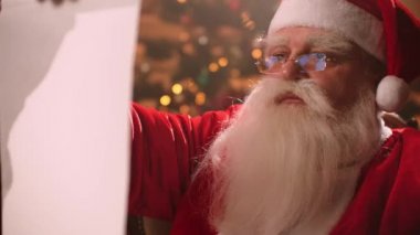 Santa Claus reads the scroll on Christmas eve and checks the list of children to whom gifts are prepared