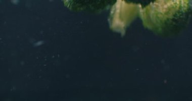 Green fresh broccoli washed in clear water before cooking, slow motion.