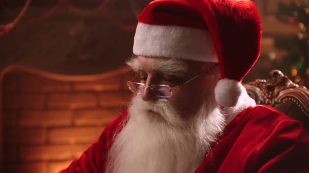 Santa Claus uses modern technology. Working at a laptop while sitting and typing on the keyboard. Online banking and Internet technologies on Christmas eve — Stok video