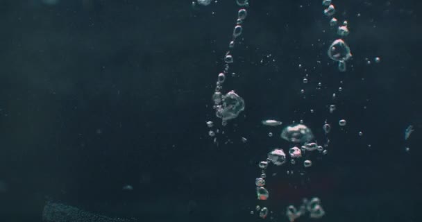 Une tomate rouge tombe dans l'eau et vole sous l'eau avec des bulles 