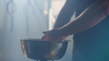 Ağır çekim portre bir atlet ellerin beyaz tebeşir tozu ile alkışlar bu toz ağır çekim parçacıklar patlar.