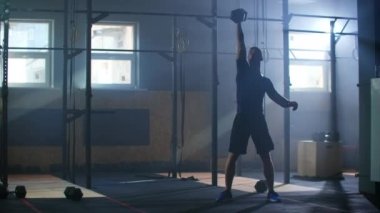 Spor salonunda bir adam ağır çekimde barfiks çekiyor..