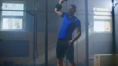 Spor salonunda bir adam ağır çekimde barfiks çekiyor..