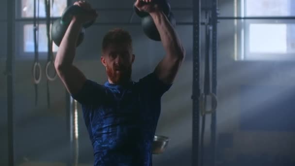 Gesunder Fitness-Mann beim Workout mit zwei Kettlebell in Zeitlupe — Stockvideo