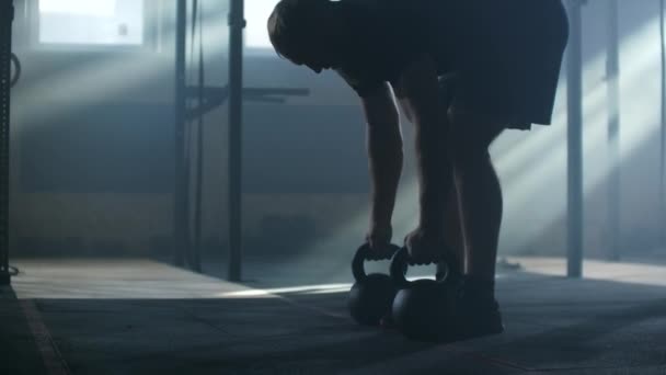 SLO MO Jeune homme balançant la kettlebell dans le centre de fitness 