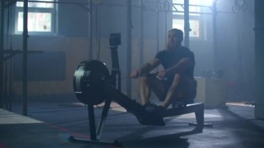 Fitness sporcusu kürek çekme makinesi eğitimi yoğun dayanıklılık egzersizi spor salonundaki güçlü sporcu fiziksel antrenmanı sağlıklı yaşam tarzı motivasyonu ellerinizi kapatın. yavaş çekim