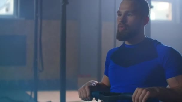 Trage beweging: fitnessman atleet training roeimachine oefening intense uithoudingsvermogen workout uitdaging sterke sportman fysieke oefening in de sportschool gezonde levensstijl motivatie — Stockvideo