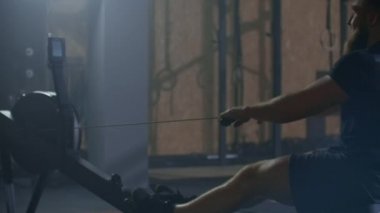 Fitness sporcusu kürek çekme makinesi eğitimi yoğun dayanıklılık egzersizi spor salonundaki güçlü sporcu fiziksel antrenmanı sağlıklı yaşam tarzı motivasyonu ellerinizi kapatın. yavaş çekim