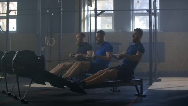 Entrenamiento de amigos de fitness en la máquina de ergómetro fila en el gimnasio cruzado — Vídeo de stock