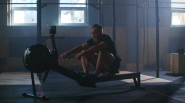 Yavaş çekim: fitness sporcusu kürek çekme makinesi yoğun dayanıklılık egzersizi spor sporcusu sağlıklı yaşam tarzı motivasyonunda güçlü bir fiziksel uygulama