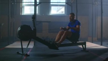 Yavaş çekim: fitness sporcusu kürek çekme makinesi yoğun dayanıklılık egzersizi spor sporcusu sağlıklı yaşam tarzı motivasyonunda güçlü bir fiziksel uygulama