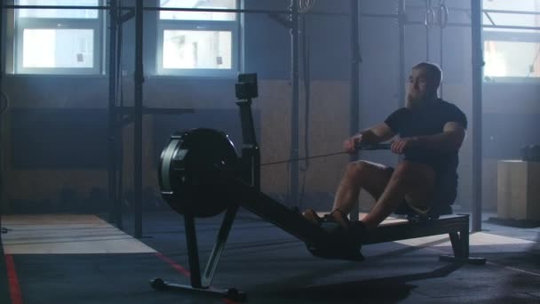 Медленное движение мужчины тренировки гребли в тренажерном зале с тренажерами и тянуть канат — стоковое видео