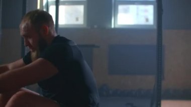 Spor salonunda kürek çekiyordum. Kürek çekme makinesi kullanan genç bir adam. yavaş çekim.