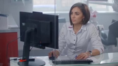 Masada oturan kadın doktor dizüstü bilgisayarda çalışıyor..