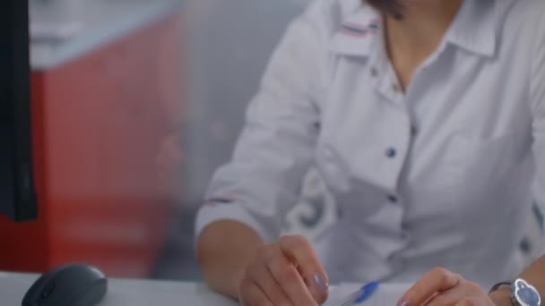 Female doctor typing on computer. Working on computer at desk. Doctor researching prescription medication. — Stock video