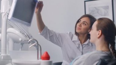 Doktor dişçi, dokunmatik ekran bilgisayarda diş röntgeni tomografisi tıbbi verilerini analiz ediyor, gece geç saatlere kadar çalışıyor, hastane konseptinde modern dijital teknolojiyle çalışıyor..