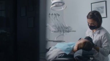 Kameranın yatay hareketi, muayeneden sonra dişçi hastayla ofiste konuşuyor. Ortodontiste danışmanlık ve muayene