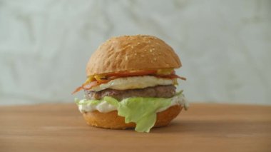 Büyük lezzetli bir hamburger, etli, köfteli, soğanlı, sebzeli, erimiş peynirli marullu..