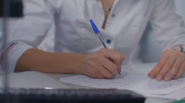 Doktor bir reçete yazar ve hastaya verir.