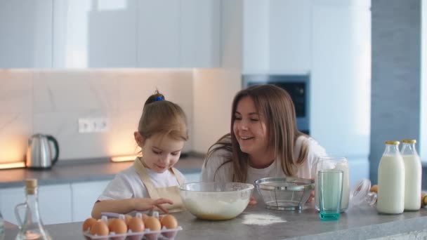 Mamá y su hija disfrutar y jugar bromas en la cocina, hija con harina untada mamás nariz y risas — Vídeos de Stock