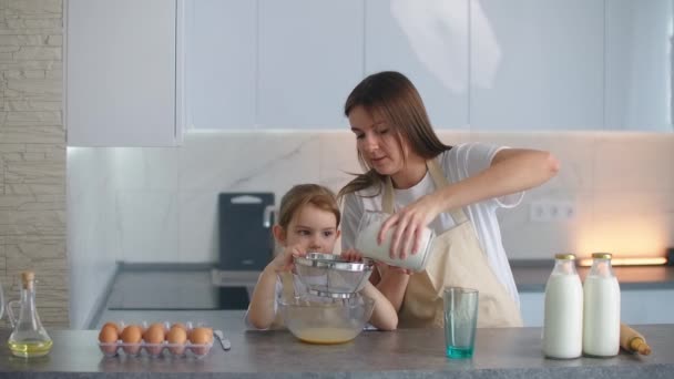 Mama streut Mehl in eine Schüssel, um einen Kuchen zu backen. — Stockvideo