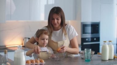 Annem ve Doug mutfakta kek pişiriyorlar. Yumurtayı birlikte kır ve hamuru bir kasede yoğur.. 