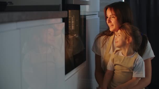 Mãe Mãe e filha assistir como uma torta é preparada no forno. Feliz infância. Fazer pizza caseira juntos — Vídeo de Stock