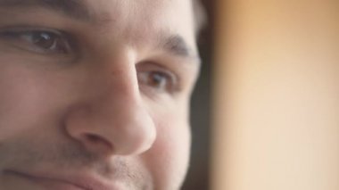 Genç serbest çalışan öğrenci dizüstü bilgisayarını kullanıyor internette çalışıyor, milenyum adamı gülümsüyor bilgisayar sörfü internetinde daktilo yazıyor ve uzaktaki işinden zevk alıyor..