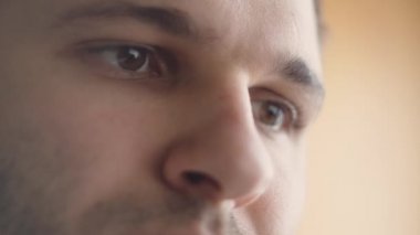 Tablet bilgisayarını kullanan ciddi bir beyaz adamın gözleri. Gözlere yansıyan ekran, ışık saçan cihazlar. 4K aşırı yakın çekim videosu.