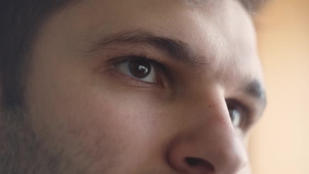 Κοντινό πλάνο των ματιών και του προσώπου ενός νεαρού άντρα που δουλεύει σε υπολογιστή. — Αρχείο Βίντεο