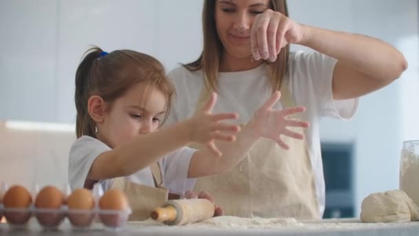 Madre e figlia che cucinano con pasta modellata in cucina. Madre e figlia in possesso di stampo pasta a forma di cuore. Scolpire l'impasto con le mani per fare spazi vuoti per pizza o torta, biscotti — Video Stock