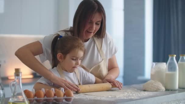 Mama pomaga córce rozpakować forsę. Mama i córeczka rozwijają kasę za pieczenie ciasteczek. przy użyciu wałka i robienia herbatników. — Wideo stockowe