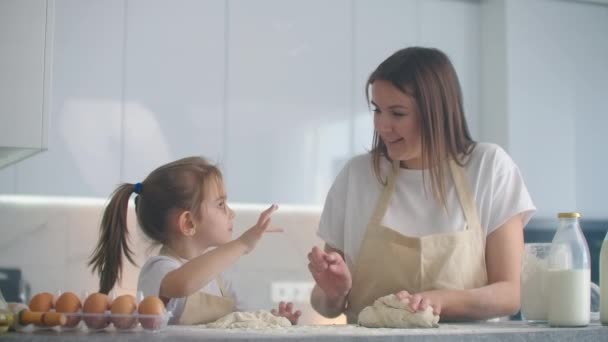 台所で生地型で母と娘の料理。母娘はハート型の生地型を持っています。ピザやパイのためのブランクを作るためにあなたの手で生地を彫刻,クッキー — ストック動画