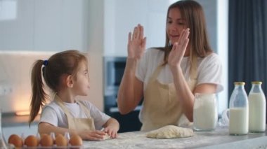 Anne ve kızı mutfakta yemek yapmayı bitirdiler ve beş soğan verdiler. Beşe bas. Ellerinde bir alkış. Mutfakta birlikte yemek pişirmek, kızını başarılı bir şekilde eğitmek.
