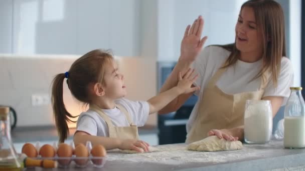 Mama i córka skończyły gotować w kuchni i dały pięć cebuli. Walić piątkę. Klaszczą w dłonie. Gotowanie razem w kuchni, pomyślnie wychowując córkę — Wideo stockowe