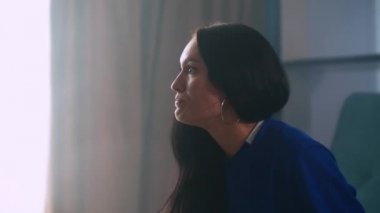 Genç ve güzel bir kadının portresi, kanepede oturmuş, elinde patlamış mısır ve birayla spor maçı seyrederken ve takımını kaybederken. Kapalı.