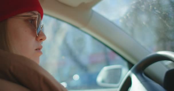 Retrato da bela jovem mulher dirigindo carro através de grande cidade ensolarada — Vídeo de Stock