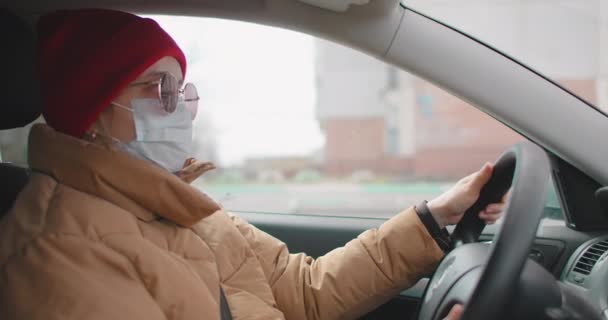 Slow-motion: Self-isolation and personal car rides during quarantine and pandemics. Coronavirus and epidemic Young Woman Wear Mask And Driving The Car. — Stock Video