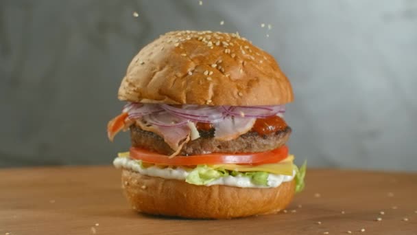 Semi di sesamo bianco che cadono in panino al rallentatore. Bun con sesamo per fare hamburger . — Video Stock