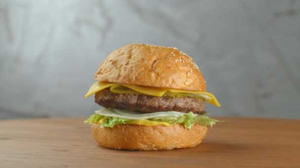 一个美味的芝士汉堡放在木制盘子里 — 图库视频影像
